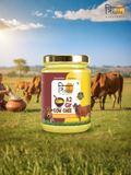A 500 gram glass jar of Trinabha Ayurvedic A2 Gir Cow Ghee set against a sunny pasture with grazing Gir cows